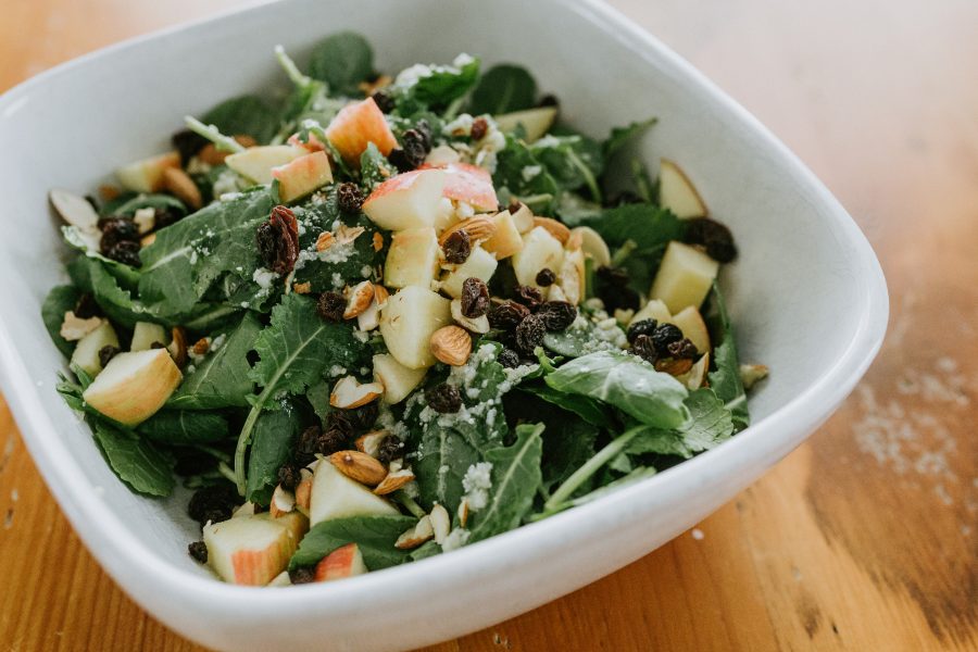 A salad from a What Cait Ate recipe featuring kale, apples, raisins and almonds. 